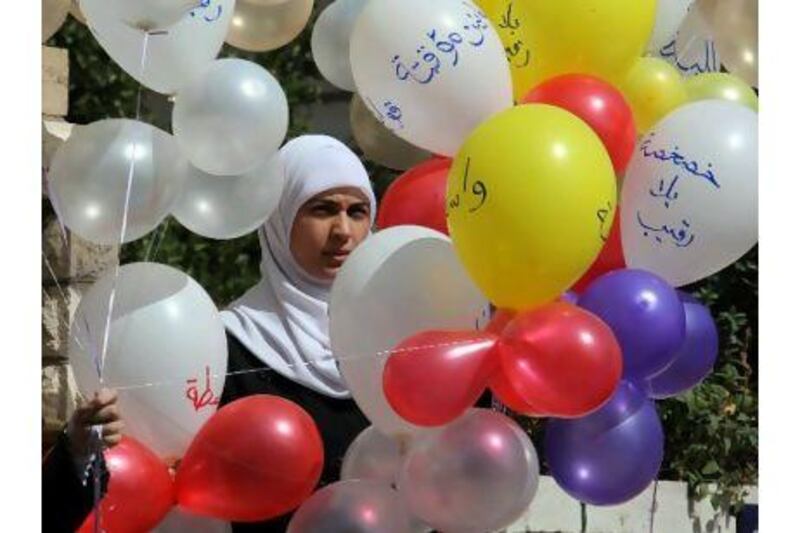 A female member of Jordan's Islamic Action Front holds balloons during a protest against the general election.