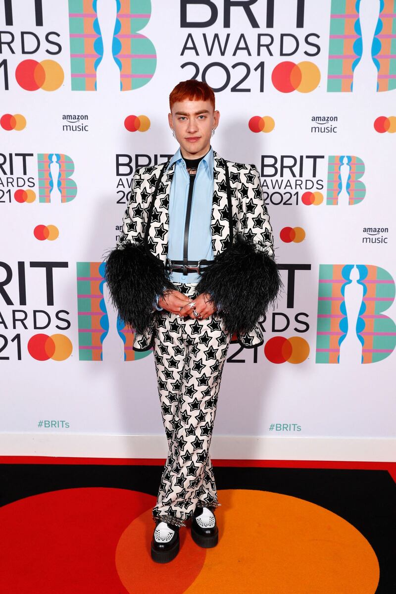 Olly Alexander of Years & Years poses on the Brits red carpet in a monochrome suit with feathered sleeves. EPA