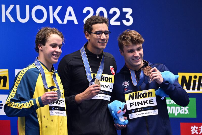 Race winner Tunisia's Ahmed Hafnaoui, centre, second-placed  Samuel Short, left, and USA's Bobby Finke at the medals ceremony for the men's 800m freestyle swimming event during the World Swimming Championships in Fukuoka on Wednesday, July 26, 2023. AFP