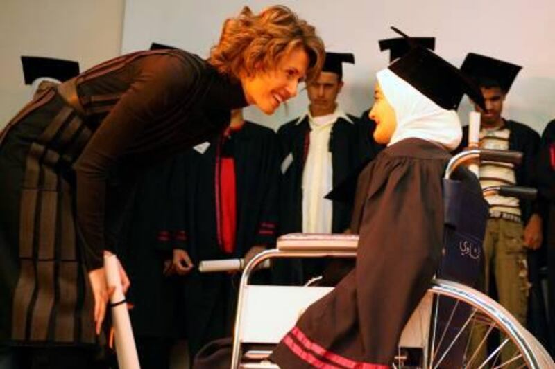Syrian First Lady Asma al-Assad readies to presents a diploma to a disabled student during a graduation ceremony in Damascus on October 22, 2008. Some 100 students from difference regions of Syrian came to Damascus to take part in the ceremony at the Syrian National Disabled Academy. AFP PHOTO/Louai BESHARA