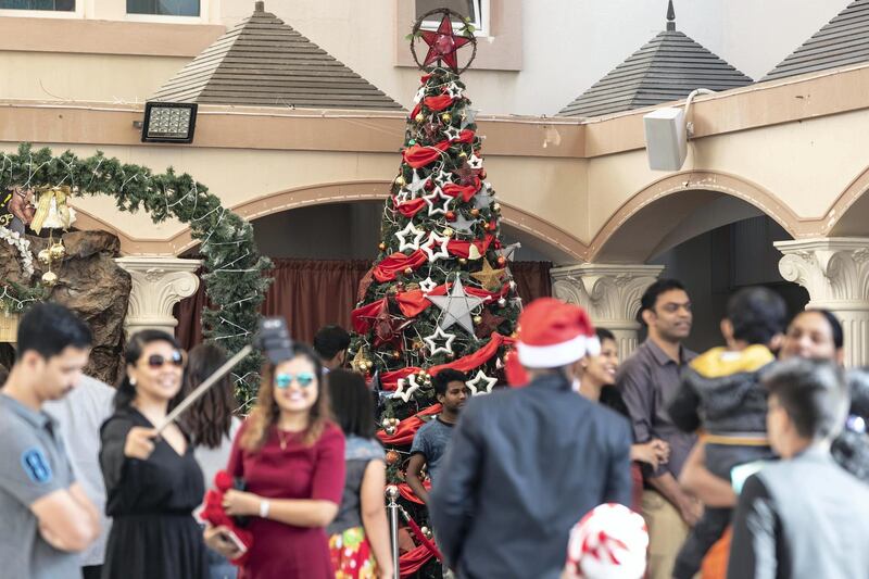 DUBAI, UNITED ARAB EMIRATES. 25 DECEMBER 2018. Coverage of Christmas Day Mass at St Francis Church in Jebel Ali. Chruch goers take pictures of themselves and family outside the church. (Photo: Antonie Robertson/The National) Journalist: Patrick Ryan. Section: National.