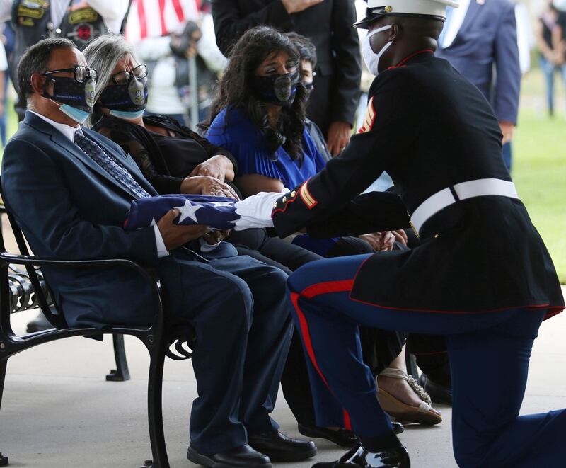 Edelmiro and Soledad Garza parents of fallen police officer Edelmiro Garza Jr., are presented with the flag from Sgt. Loren Thomas with the 1st Battalion, 23rd Marines from Harlingen, Texas. AP Photo