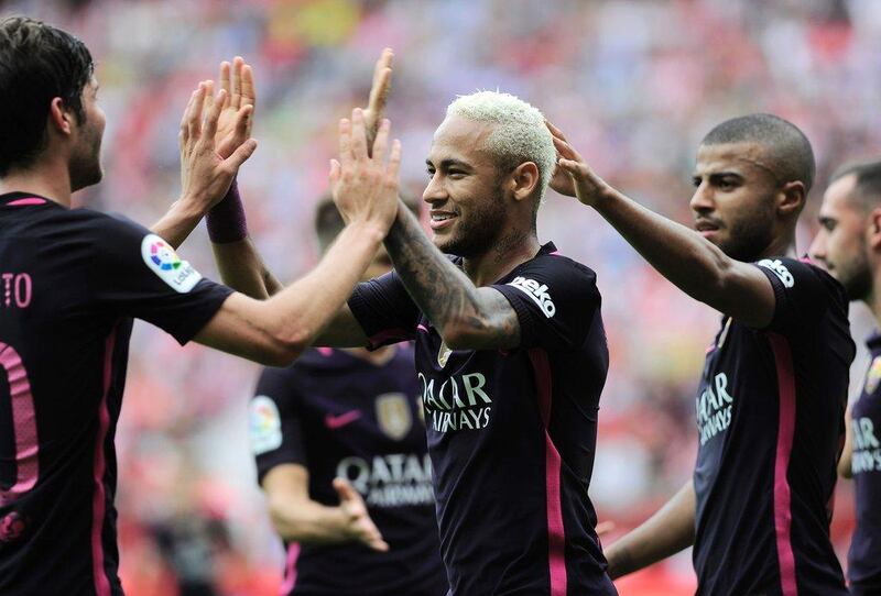 Neymar celebrates with teammates after scoring Barcelona’s third goal. Ander Gillenea / AFP