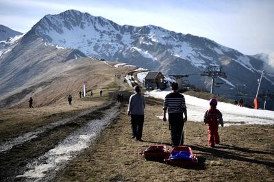 People pull a sled on the top of a ski slope on February 15, 2020 in the Superbagneres station, near Luchon, in French Pyrenees mountain southwestern France. The French department of Haute-Garonne decided to pour snow by helicopter on the Luchon-Superbagnères station in order to make up for the lack of snow on February 14 and February 15, 2020. / AFP / Anne-Christine POUJOULAT
