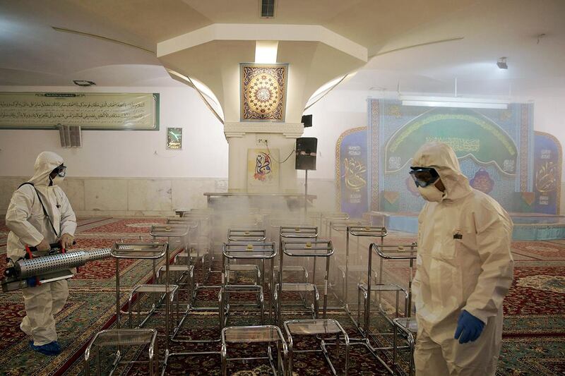 FILE PHOTO: Members of a medical team spray disinfectant to sanitize indoor place of Imam Reza's holy shrine, following the coronavirus outbreak, in Mashhad, Iran February 27, 2020. Picture taken February 27, 2020. WANA (West Asia News Agency) via REUTERS ATTENTION EDITORS - THIS PICTURE WAS PROVIDED BY A THIRD PARTY/File Photo