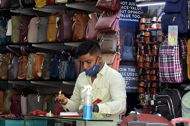A shopkeeper offers prayers after he reopened his store in Mumbai.