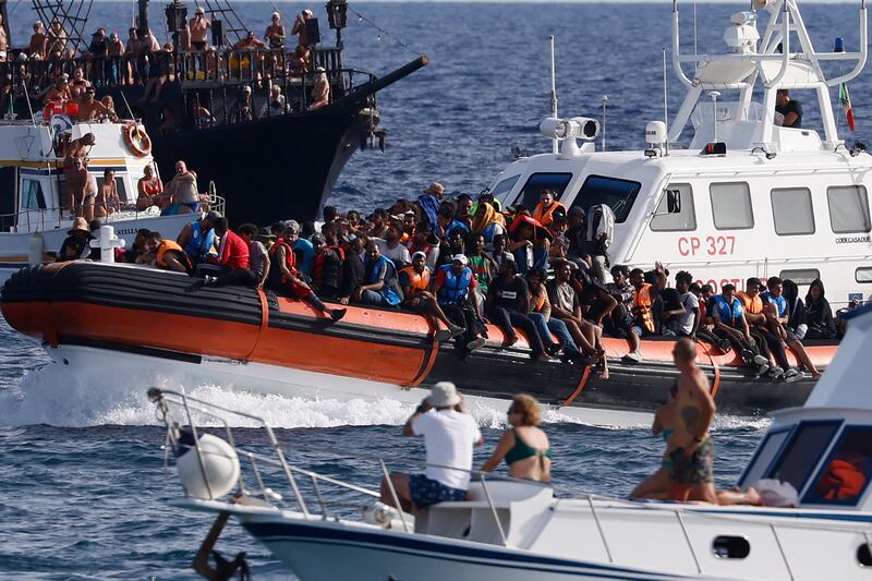 An Italian coastguard boat carries a group of migrants near the port of the Sicilian island of Lampedusa. La Presse / AP