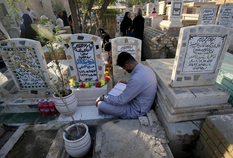 Iraqis pray at the grave of loved ones at a cemetery in the capital Baghdad.  Ahmad Al Rubaye / AFP Photo
