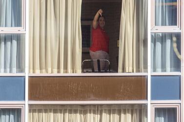 A traveller in compulsory quarantine gives the thumbs-down from her room at the Radisson Blu hotel near Heathrow Airport, London. Getty