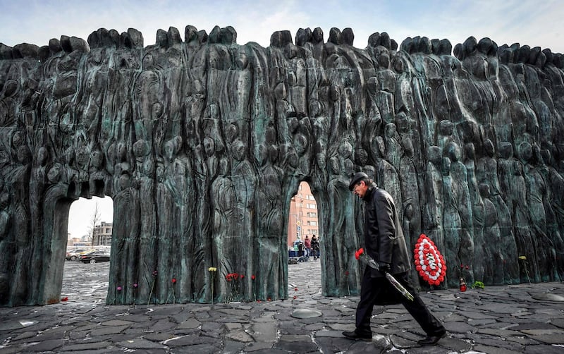 A Russian arrives to lay flowers at the 'Wall of Grief', a memorial dedicated to the victims of political repression, in central Moscow. AFP