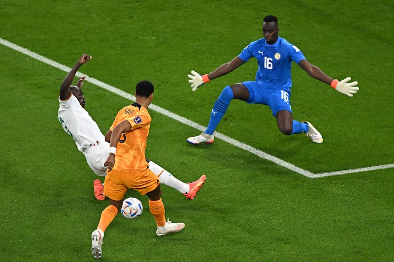 Senegal defender Kalidou Koulibaly slides in on Netherlands' forward Cody Gakpo as Senegal keeper Edouard Mendy watches on. AFP