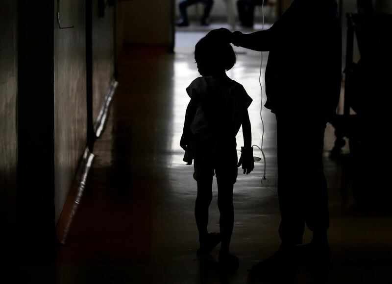 A young dengue patient walks inside the San Lazaro government hospital in Manila. 