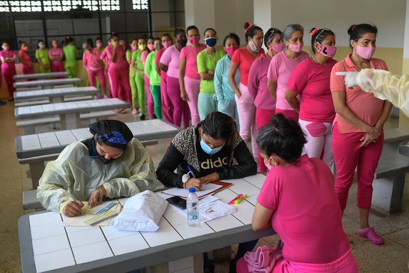 An inmate gives her details to staff after she was inoculated with the Sinopharm vaccine at the women's prison in Los Teques, Venezuela.