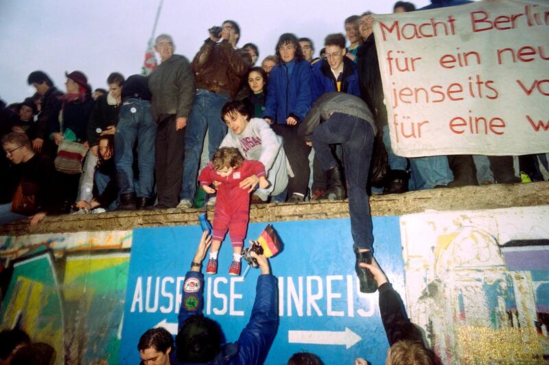 People from East Germany greet citizens of West Germany at the Brandenburg Gate in Berlin on December 22, 1989. On November 09, Gunter Schabowski, the East Berlin Communist party boss, declared that starting from midnight, East Germans would be free to leave the country, without permission, at any point along the border, including the crossing-points through the Wall in Berlin. The Berlin concrete wall was built by the East German government in August 1961 to seal off East Berlin from the part of the city occupied by the three main Western powers to prevent mass illegal immigration to the West. According to the "August 13 Association" which specialises in the history of the Berlin Wall, at least 938 people - 255 in Berlin alone - died, shot by East German border guards, attempting to flee to West Berlin or West Germany. PATRICK HERTZOG (Photo by PATRICK HERTZOG / AFP)