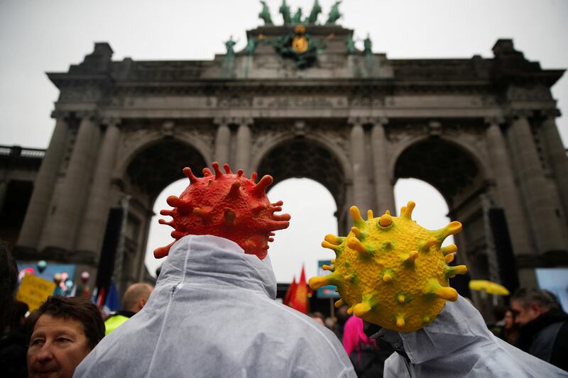 Demonstrators wear coronavirus-themed headgear in Brussels. Reuters