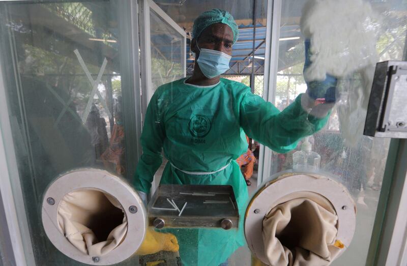 An employee cleans a booth at a testing and screening centre for the coronavirus, at a hospital in Karachi, Pakistan. AP Photo