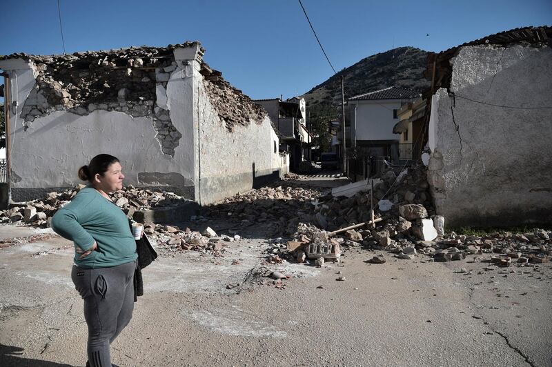 A woman stands by damaged old buildings in the village of Damasi, near Larissa. AFP