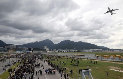 epa07809229 A plane flies overhead as protesters block a road leading to the Hong Kong International Airport in Hong Kong, China, 01 September 2019. Anti-government protesters are planning to disrupt all travel routes to Hong Kong airport on 01 and 02 September. Hong Kong has been gripped by mass protests since June over a now-suspended extradition bill, which has since morphed into a wider anti-government movement.  EPA/JEROME FAVRE  EPA-EFE/JEROME FAVRE