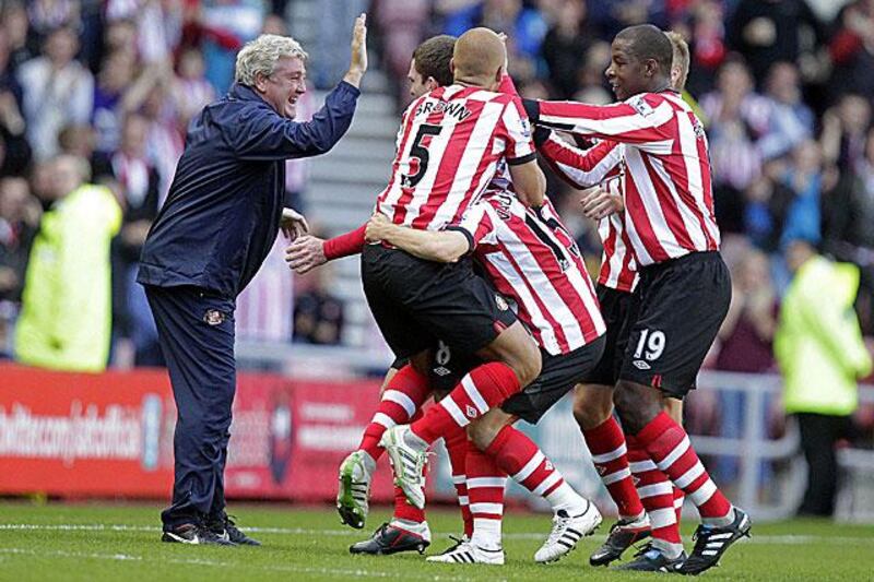 The Sunderland manager Steve Bruce, left, celebrates with his players after Craig Gardner scored the Black Cats third in their 4-0 win against Stoke City.

Graham Stuart / AFP