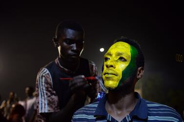 A Sudanese protester gets his face painted during their sit-in outside the army headquarters in Khartoum on May 9, 2019. AFP 
