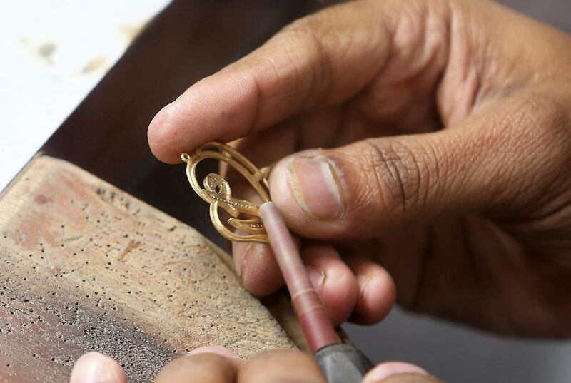 A Damas artisan shapes a gold jewellery at the company's factory. Pawan Singh / The National
