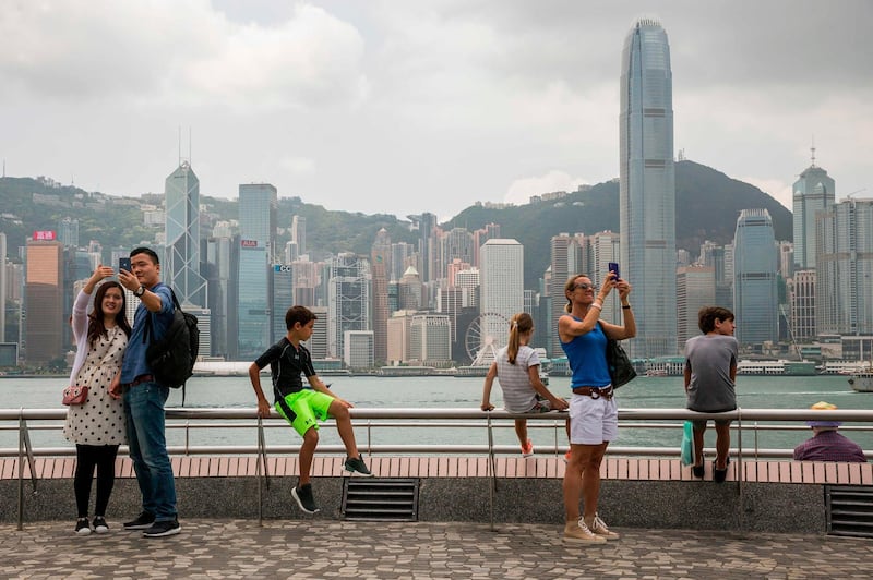 A couple take a selfie while standing on the Tsim Sha Tsui observation deck that overlooks Victoria Harbour and the skyline of Hong Kong. Isaac Lawrence / AFP