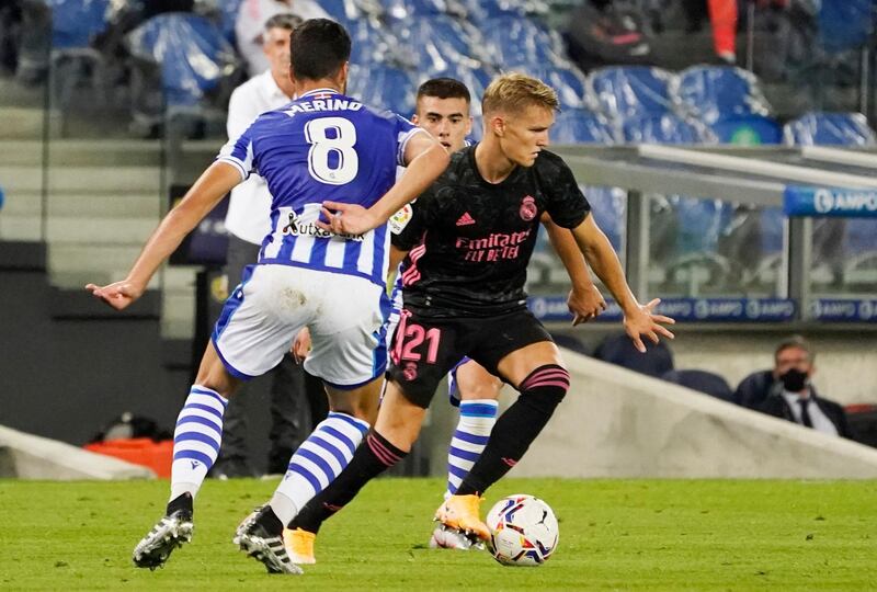 Martin Odegaard shields the ball against pressure from Real Sociedad players. Reuters