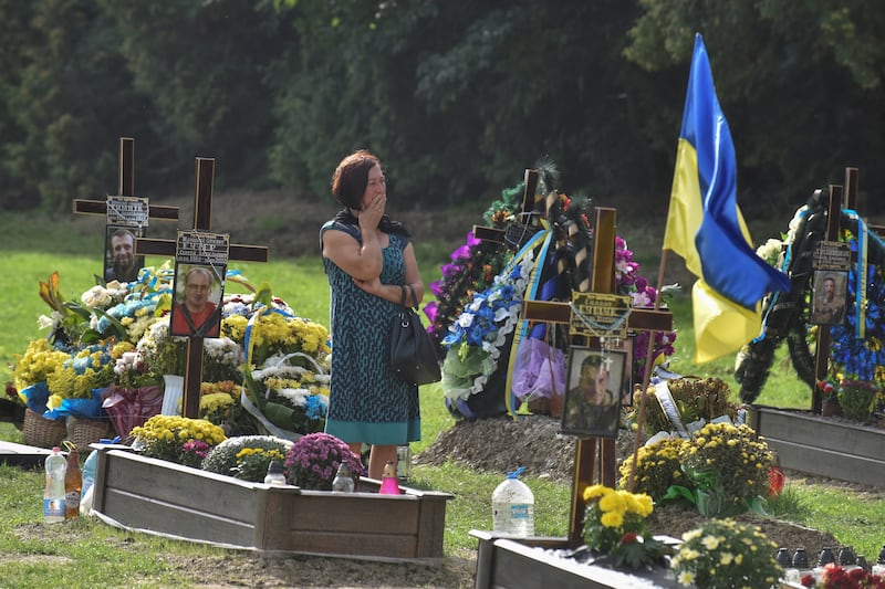 A woman visits the tomb of her relative, a Ukrainian serviceman who was killed in a fight against Russian troops, in Lviv. Reuters