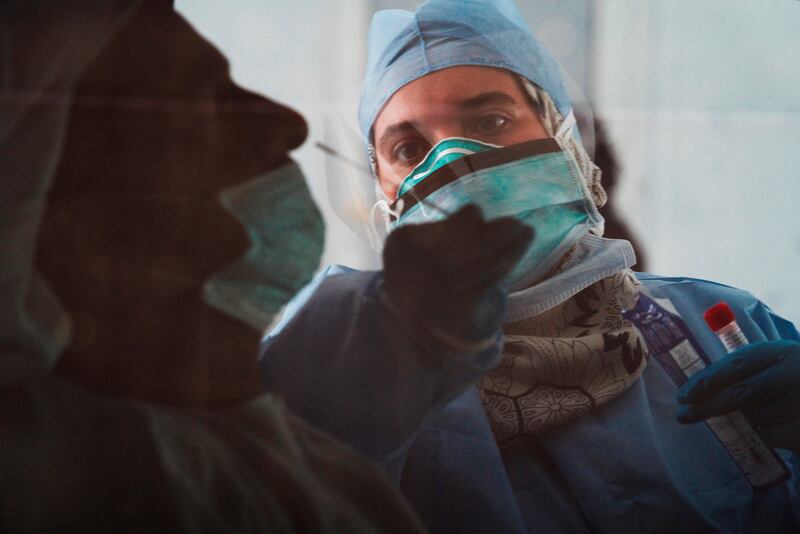 A technician takes a nasal swab for a coronavirus detection test at a drive-through testing facility in Abu Dhabi in April 2020. AP Photo