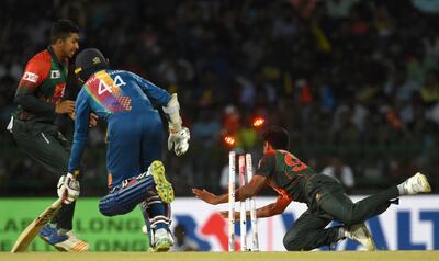 Bangladesh cricketer Mustafizur Rahman (R) dismisses Sri Lanka's Upul Tharanga (C) during the sixth Twenty20 (T20) international cricket match between Bangladesh and Sri Lanka of the tri-nation Nidahas Trophy at the R. Premadasa stadium in Colombo on March 16, 2018. / AFP PHOTO / ISHARA S. KODIKARA