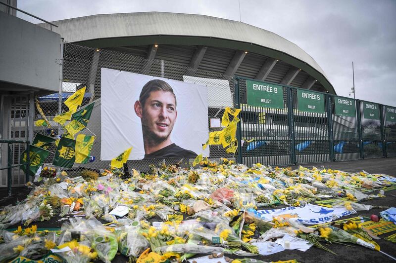 (FILES) In this file photo taken on February 8, 2019 yellow flowers are displayed in front of the portrait of Argentinian forward Emiliano Sala at the Beaujoire stadium in Nantes.  Cardiff City and former Nantes footballer Emiliano Sala died in a plane crash in the English Channel on January 21, 2019. / AFP / LOIC VENANCE
