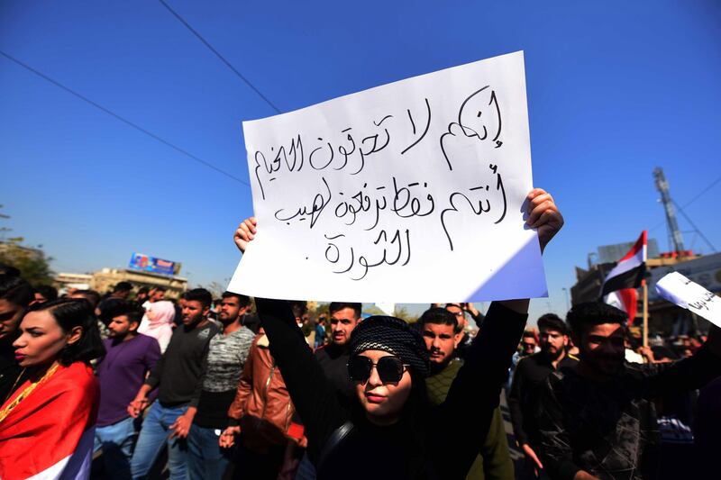 An Iraqi university student holds a placard reading in Arabic 'you do not burn tents, but you are fuelling revolution' during a protest in central Baghdad, Iraq.  EPA