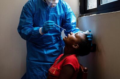 A healthcare worker prepares to take a nasal swab on an Ethiopian woman to test for COVID-19. Finbar Anderson for The National