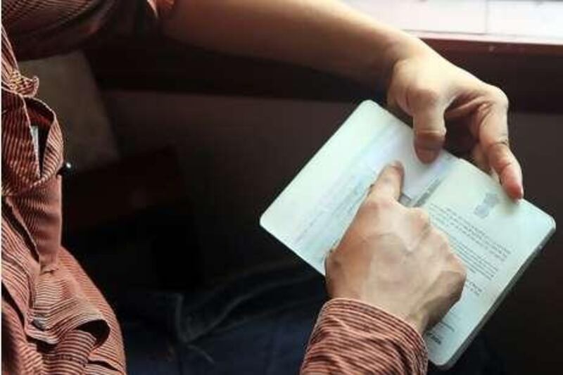 A man shows his fake passport, which he has used to travel to the UAE three times.