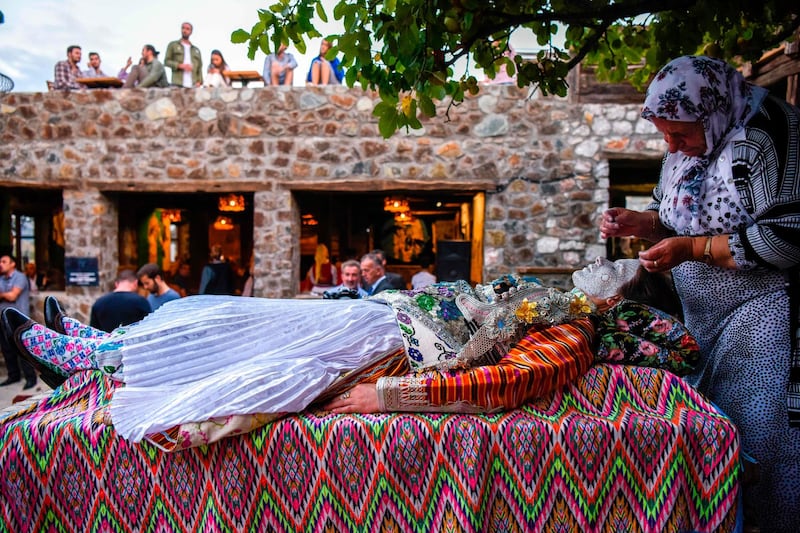 Buqaj lays on her back as she receives a traditional face painting by Sefitagic. AFP