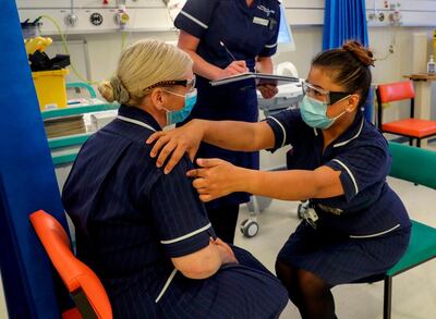 Eearing a protective face coverings to combat the spread of the coronavirus, Matron May Parsons (R) talks to Heather Price (L) during training in the Covid-19 Vaccination Clinic at the University Hospital in Coventry, central England on December 4, 2020, prior to the NHS administering jabs to the most vulnerable early next week. Britain insisted Friday its world-first approval of the Pfizer-BioNTech coronavirus vaccine met all safety standards, striving to tamp down any public unease after US and European officials queried the rapid process.  / AFP / POOL / Steve Parsons
