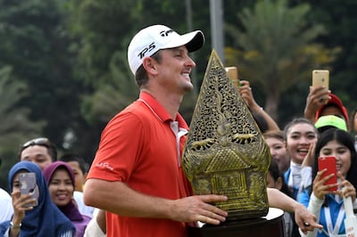 Justin Rose of England celebrates with the trophy after winning the Indonesian Masters golf tournament in Jakarta on December 17, 2017. / AFP PHOTO / GOH CHAI HIN