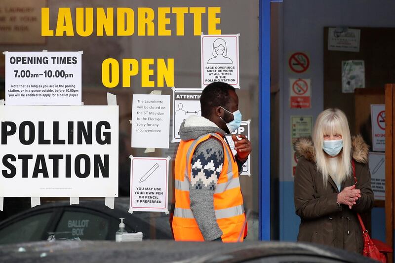 A voter sanitizes her hands as she leaves a polling station during local elections in Oxford. Reuters