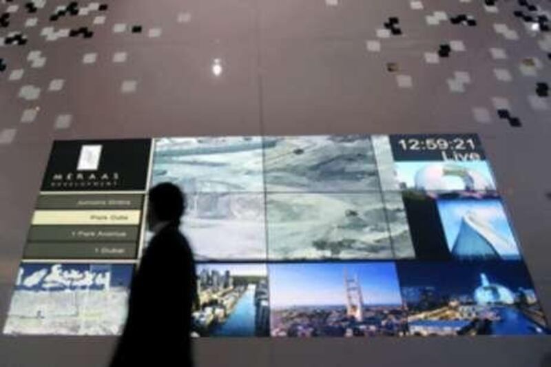 A man walks past a projection of Meraas Developement at Cityscape Dubai at the Dubai International Exhibition Center. The company is reviewing one of its showpiece developments, Jumeriah Gardens.