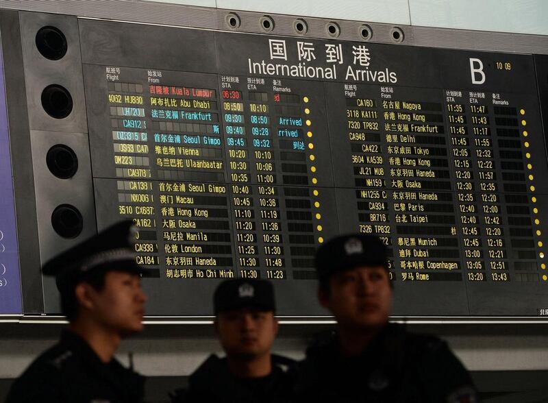 Chinese police stand beside the arrival board showing the flight MH370 (top-red) at the Beijing Airport after news of the Malaysia Airlines Boeing 777-200 plane disapearing. AFP