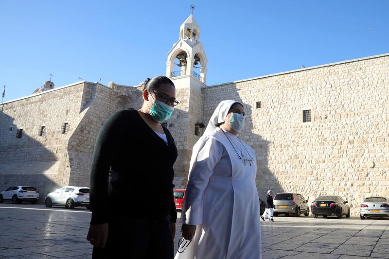 Christians walk towards the Church of the Nativity that reopened Tuesday to visitors after a nearly three-month closure due to the coronavirus pandemic, in Bethlehem, West Bank, Tuesday, May 26, 2020. (AP Photo/Mahmoud Illean)