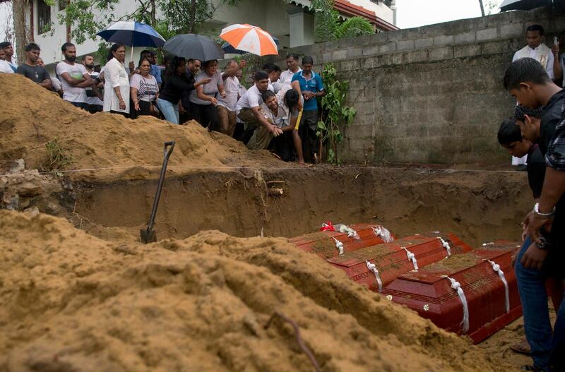 Relatives bury three members of the same family at St Sebastian Church. AP Photo