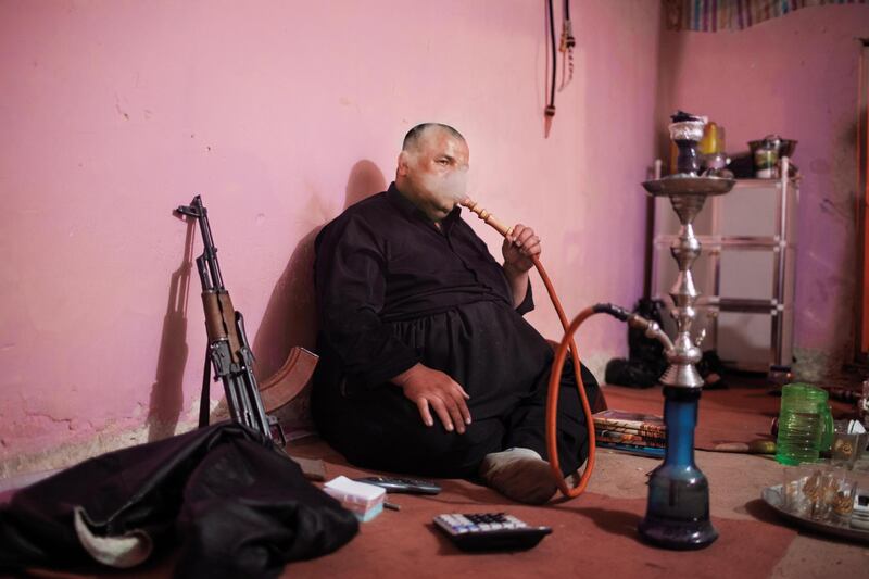 BASHMAX, IRAQ: Tariq, a smuggler, sits in his den watching TV. Photo by  Sebastian Meyer