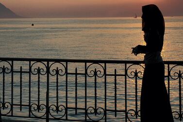 An Arab woman at sunset at Lake Geneva, Switzerland ahead of a referendum on wearing of the burqa. Alamy