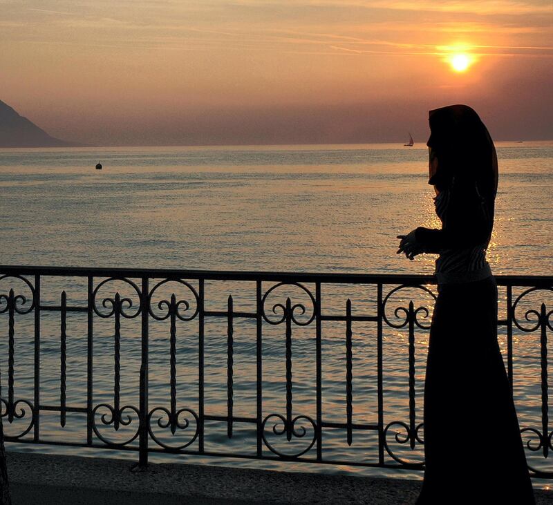 EBDPF1 silhouette of single Arab woman sunset at Geneva Lake, Montreux, Swiss Riviera, Switzerland