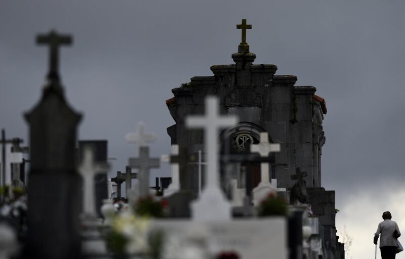 A woman walks along tombs at the municipal cemetery of San Salvador in Oviedo, northern Spain. Eloy Alonso / Reuters