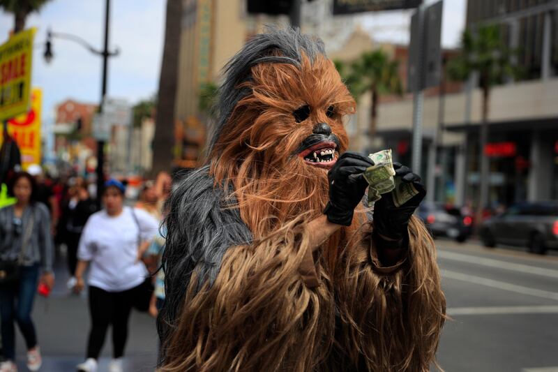 Donte, a musician who only gave his first name, straightens out dollar bills on his first day in a brand new Chewbacca costume purchased from eBay for $441, in the Hollywood section of Los Angeles. Donte said he replaced the old one because he wasn't making any money with it. Jae C Hong / AP Photo