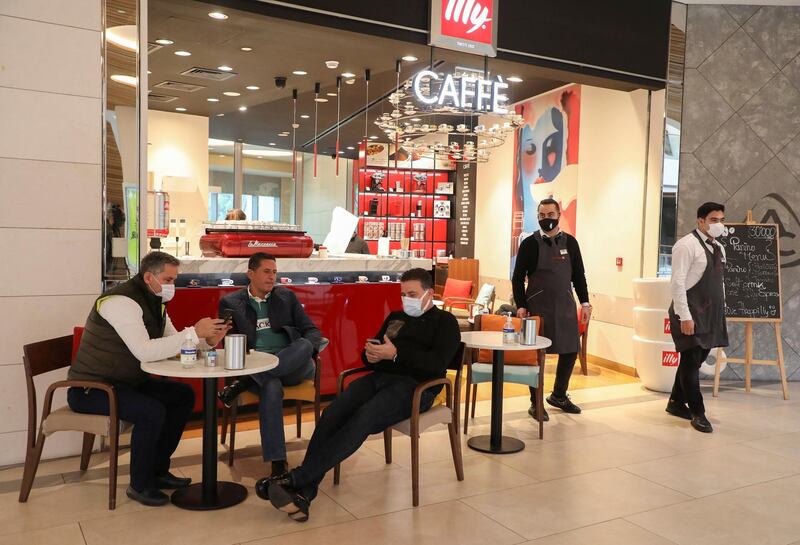 Men sit at an Illy Caffe inside a shopping mall that has reopened, as the coronavirus disease (COVID-19) restrictions are eased, in Beirut, Lebanon. Reuters