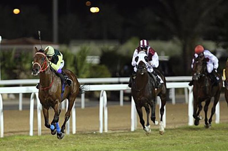 Dynamite, ridden by Royston Ffrench, left, comes home first during the National Day Cup race for purebred Arabians yesterday.