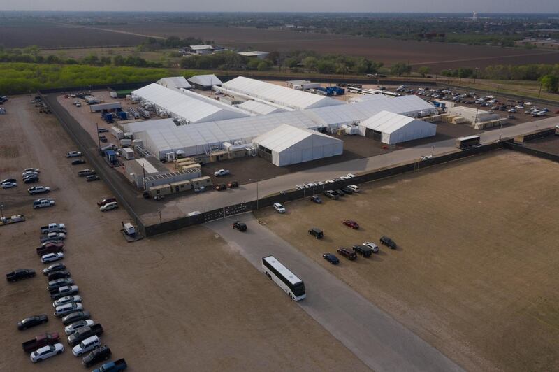 A tour bus exits a U.S. Customs and Border Protection temporary processing center after dropping off migrants in Donna, Texas, U.S., March 15, 2021. Picture taken with a drone. REUTERS/Adrees Latif